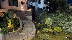A landscaped garden with a stone staircase leading to a house entrance, surrounded by various plants and a hedge. - Entire Building for Groups of 16+ in Medellín (Medellín)
