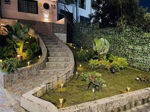 A landscaped garden with a stone staircase leading to a house entrance, surrounded by various plants and a hedge. - Entire Building for Groups of 16+ in Medellín (Medellín)