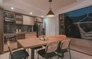 A modern kitchen with a dining area, large windows, and a view of the outdoors. - Entire Building for Groups of 16+ in Medellín (Medellín)