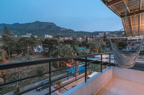 A balcony with a view of a residential area, a hanging chair, and a pool. - Entire Building for Groups of 16+ in Medellín (Medellín)