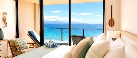 A bedroom with a large window, a bed, a chair, and a ceiling fan.