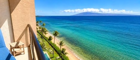 A balcony with a view of a beach and ocean.
