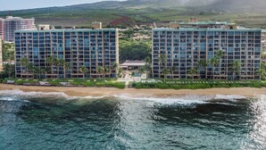 A beachfront hotel with multiple high-rise buildings, a beach, and a mountainous backdrop. - Mahana Resort | Oceanfront Studio Sleeps 2 | Car Incl. w/ 6+ Nights | MAH-1002 by KBM (Lahaina)