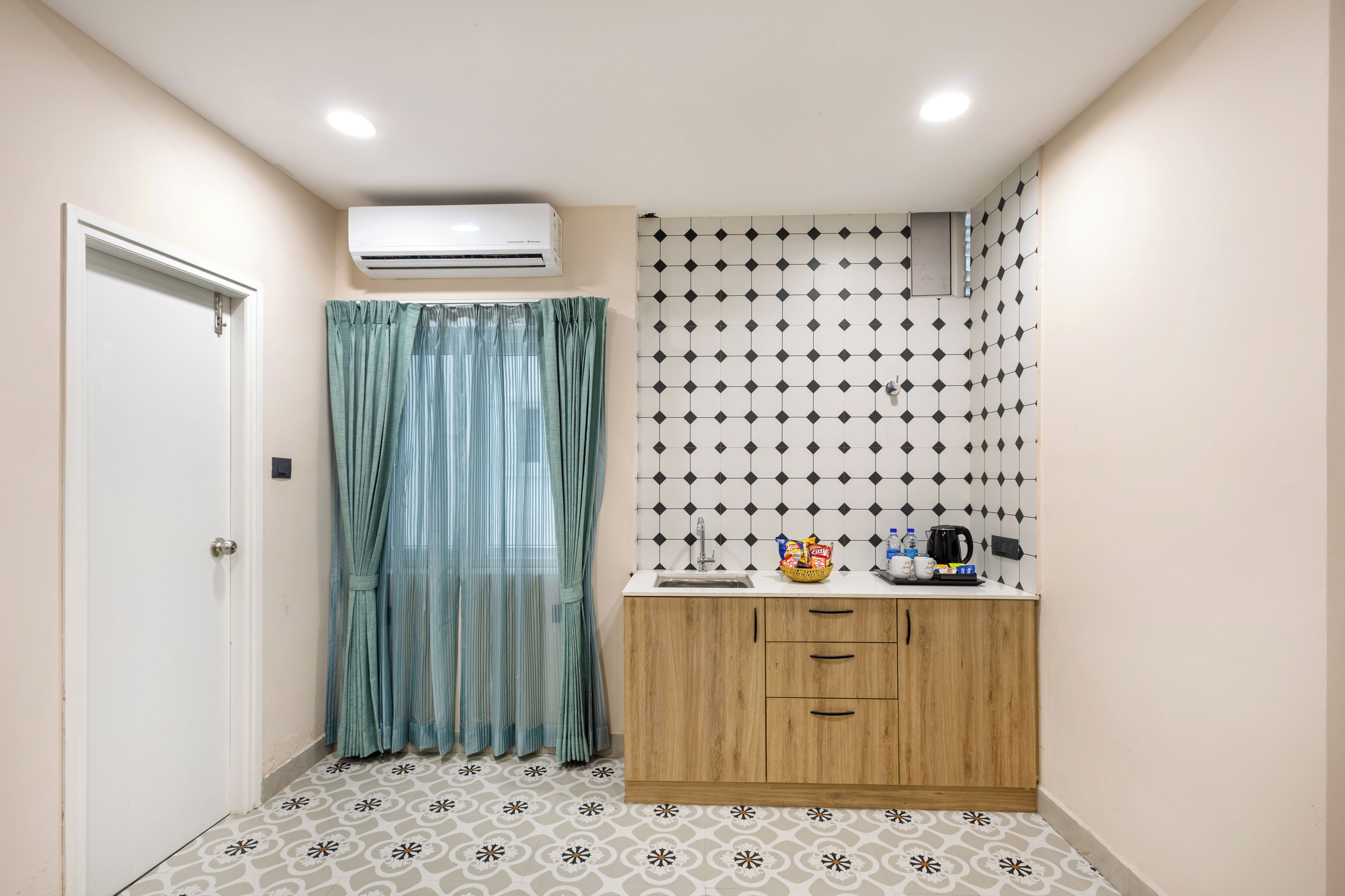 Un baño con cortina de ducha, lavamanos con artículos de aseo y azulejos estampados en las paredes.