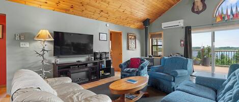 A cozy living room with a television, sofas, a coffee table, and a fireplace.