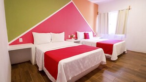 A hotel room with two beds, a window with curtains, and a wall with a geometric design.