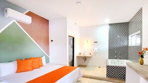 A hotel room with a bed, a bathroom with a bathtub, and a shower area.