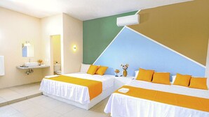 A hotel room with two beds, a bathroom, and a green wall.