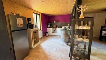 Una cocina con refrigerador, microondas y un mueble de madera.