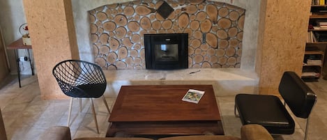 Un salon chaleureux avec une cheminée, une horloge et un canapé.