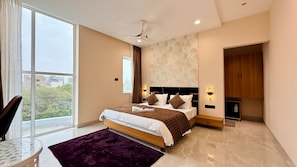 Un dormitorio moderno con una cama grande, un ventilador de techo, vistas al exterior y un armario de madera.