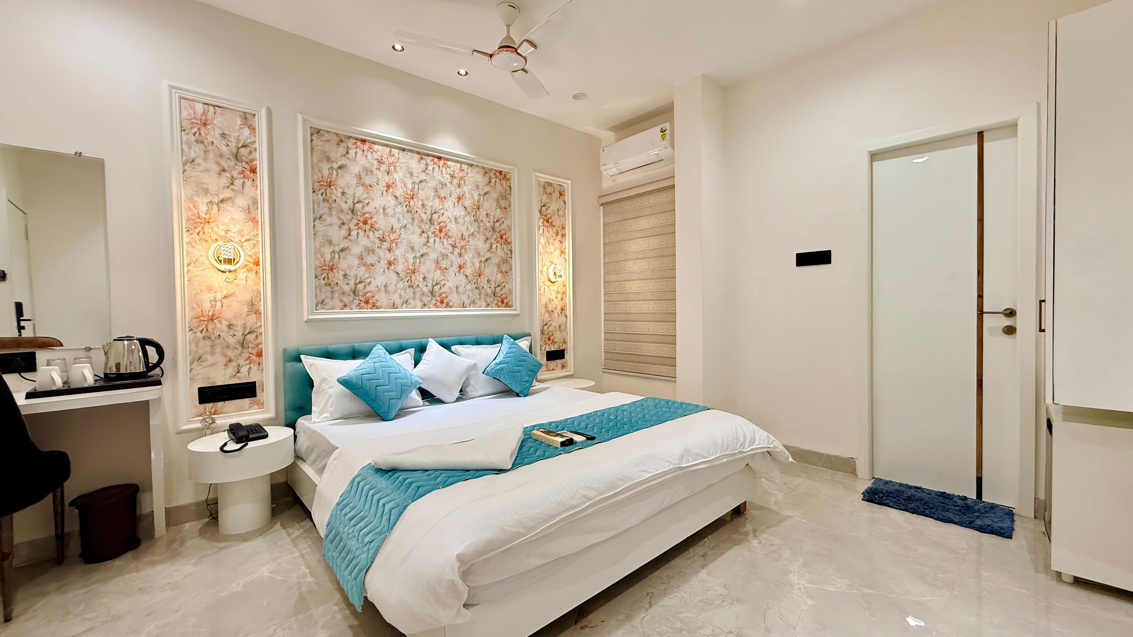 A hotel room with a bed, bedside table, and a wardrobe.