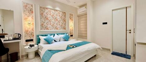 A hotel room with a bed, bedside table, and a wardrobe.
