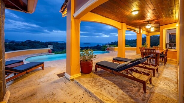 Un espace extérieur abrité comprenant une piscine, des chaises longues et une table à manger.