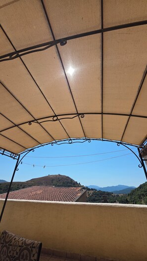 A covered outdoor area with a view of a hilly landscape. - Village house (Castifao)