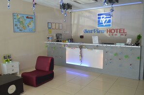 Un mostrador de recepción con un logotipo, un mapa, certificados y una silla roja.