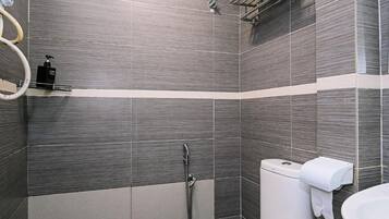 A modern bathroom with a shower, toilet, and sink.