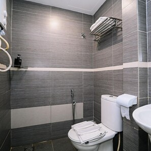 Un baño moderno con ducha, inodoro y lavamanos.