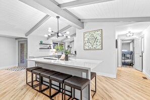 A modern kitchen with a large island, bar stools, and a pendant light. - Park like setting on the Applegate River great for wine tasting & family reunion (Jacksonville)