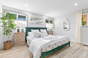 A bedroom with a bed, a nightstand, a dresser, a potted plant, and a window with curtains. - Park like setting on the Applegate River great for wine tasting & family reunion (Jacksonville)