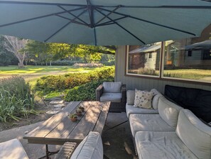 An outdoor patio with a covered seating area, a wooden table, and potted plants. - Park like setting on the Applegate River great for wine tasting & family reunion (Jacksonville)