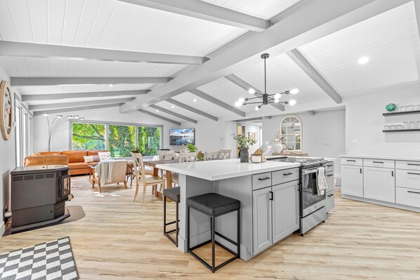A spacious living area with a large island, a kitchen with modern appliances, and a dining area with natural light. - Park like setting on the Applegate River great for wine tasting & family reunion (Jacksonville)