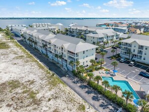 A coastal hotel with multiple-story buildings, a swimming pool, and a beachside location.