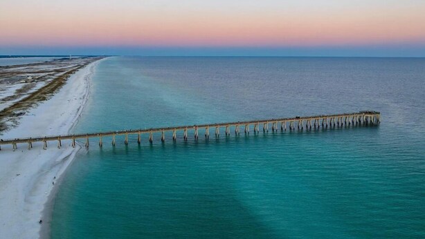 A coastal scene with a long pier extending into the water, a sandy beach, and a clear sky. - 🐾 Sound & Sea | Pet Friendly Gated Community | Bikes + Beach Gear Navarre (Navarre)