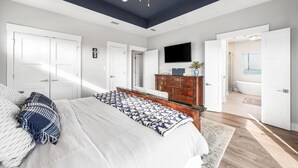 A bedroom with a bed, dresser, TV, and a ceiling fan. - 🐾 Sound & Sea | Pet Friendly Gated Community | Bikes + Beach Gear Navarre (Navarre)