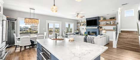 A spacious kitchen with a large island, modern appliances, and a view to the outside.