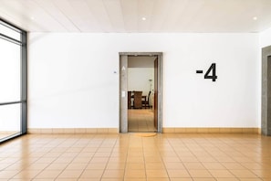 A hallway with a tiled floor leading to a door marked with the number -4. - SunDream Apart I (Funchal)