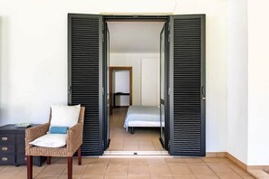 A room with a bed, a chair, and a wardrobe with open doors. - SunDream Apart I (Funchal)