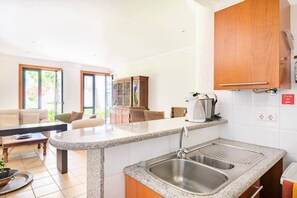 A modern kitchen with granite countertops, stainless steel sinks, and wooden cabinets. - SunDream Apart I (Funchal)