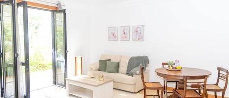 A living room with a sofa, coffee table, and dining table with chairs.
