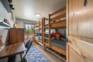 Una habitació amb lliteres, un escriptori i una cadira.