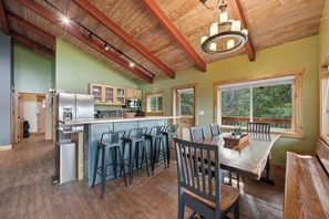 A spacious kitchen with a central island, bar stools, and a dining table with chairs. - Minutes to Whitefish Lake and Mountain (Whitefish)