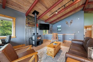 A cozy living room with a fireplace, seating area, and a television. - Minutes to Whitefish Lake and Mountain (Whitefish)