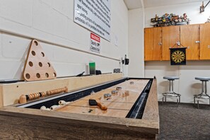 Ein Billardtisch mit einem Holz-Dreieckständer, Spielstöcken und nummerierten Billardkugeln.