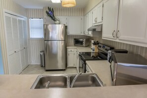 A kitchen with stainless steel appliances, a sink, and white cabinetry. - Beachfront Villa With Sea Views Bikes Included Gulf Across St Kayak Access (Miramar Beach)