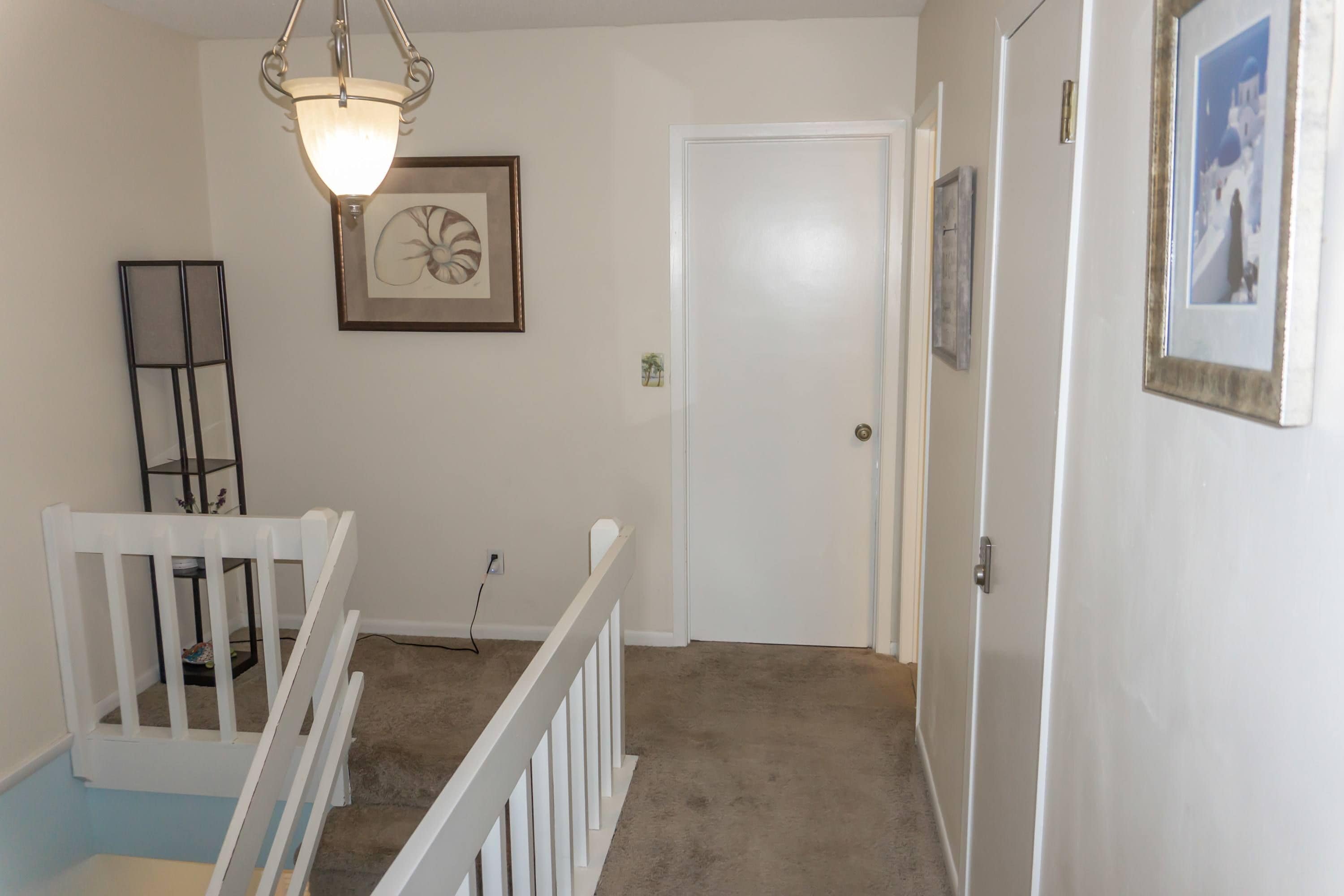 A staircase with white railings leading to a door.