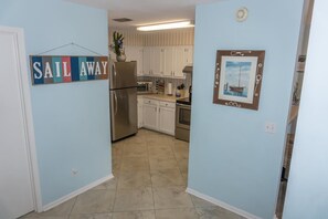 A kitchen with white cabinets, a stainless steel refrigerator, and a tiled floor. - Beachfront Villa With Sea Views Bikes Included Gulf Across St Kayak Access (Miramar Beach)