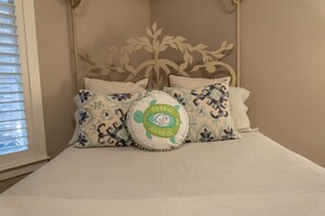 A bed with a headboard, three pillows, and a window with blinds. - Gated Beach Villa w 2 Pools 3 Bikes Included Tennis Pickleball Courts Included (Miramar Beach)