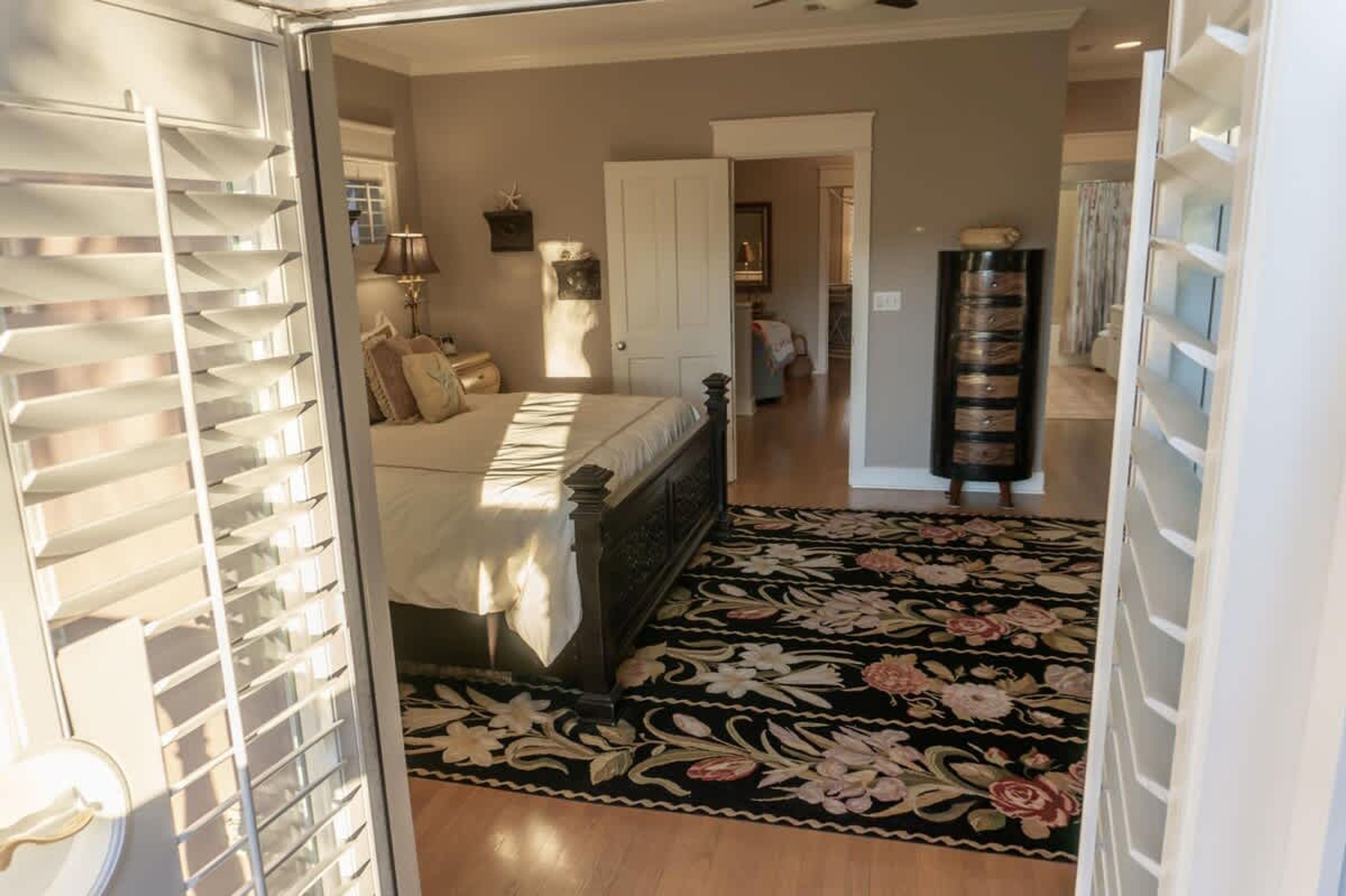 A bedroom with a bed, bedside tables, a lamp, and a window with blinds.