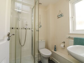 A bathroom with a glass-enclosed shower, a toilet, a sink, and a window. - Honeycombe Lodge (Gunnislake)