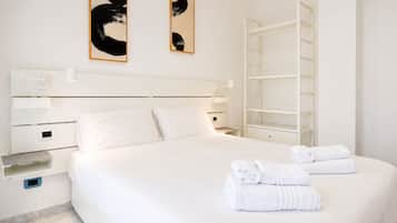 Ein Hotelzimmer mit einem großen Bett, einem Nachttisch, einem Kleiderschrank und Bildern an der Wand.