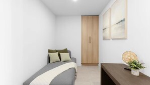 A small, modern bedroom with a bed, a wooden wardrobe, and a bedside table with a plant. - 501 First #3410 Skyline Dreamscape Retreat (Miami)
