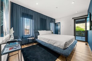 Ein modernes Schlafzimmer mit einem großen Bett, einem Schreibtisch mit Stuhl und einem Fenster mit Vorhängen.