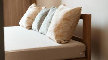 A bed with a wooden headboard and a mattress with a visible brand label.