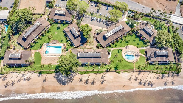 An aerial view of a resort with multiple buildings, a swimming pool, and a beach area. - Beachfront 4BR, 2 Condos for 12 at Maalaea Surf! (Kihei)