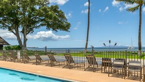 A pool area with lounge chairs and a view of the ocean. - Beachfront 4BR, 2 Condos for 12 at Maalaea Surf! (Kihei)